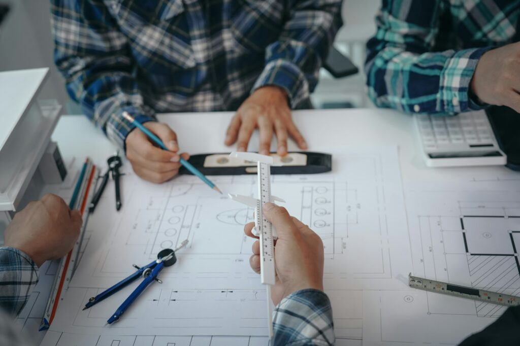 Team of engineers in a meeting, drawing blueprints for condo, apartment, and house construction.