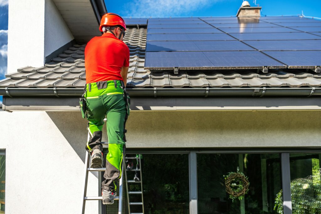 Professional Worker Installing Solar Panels on Roof